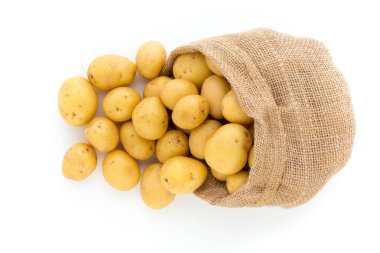 Ahşap arka planda taze çiğ patates çuvalı.