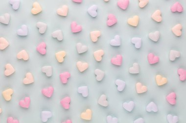 Sevgililer Günü geçmişi. Pastel mavi arka planda şeker kalpli kompozisyon. Sevgililer Günü tebrik kartı. Düz yatış, üst görünüm.