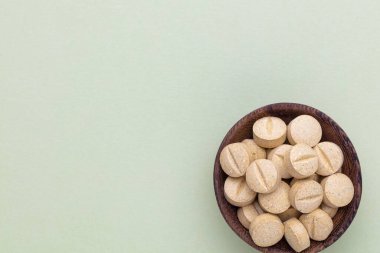 Vitamin hapı tableti, mineral ve takviye maddesi, bitkisel ilaç tozu tıp pastel arka planında fotokopi alanı ile birlikte..
