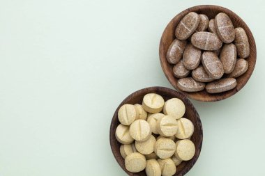 Vitamin hapı tableti, mineral ve takviye maddesi, bitkisel ilaç tozu tıp pastel arka planında fotokopi alanı ile birlikte..