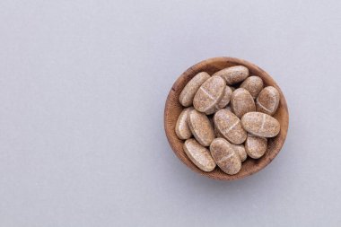 Vitamin hapı tableti, mineral ve takviye maddesi, bitkisel ilaç tozu tıp pastel arka planında fotokopi alanı ile birlikte..