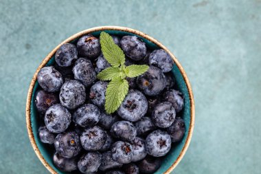 Pasta masasında yeşil nane yapraklı taze yabanmersini.. 
