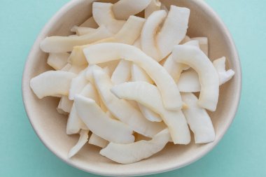 Hafif arkaplanda lezzetli hindistan cevizi parçacıkları olan kase.