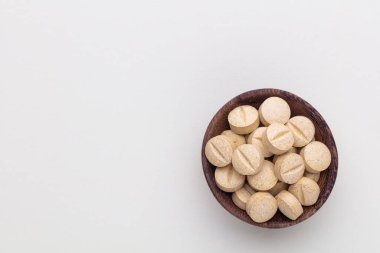 Vitamin hapı tableti, mineral ve takviye maddesi, bitkisel ilaç tozu tıp pastel arka planında fotokopi alanı ile birlikte..