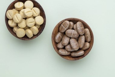 Vitamin hapı tableti, mineral ve takviye maddesi, bitkisel ilaç tozu tıp pastel arka planında fotokopi alanı ile birlikte..