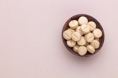 Vitamin hapı tableti, mineral ve takviye maddesi, bitkisel ilaç tozu tıp pastel arka planında fotokopi alanı ile birlikte..