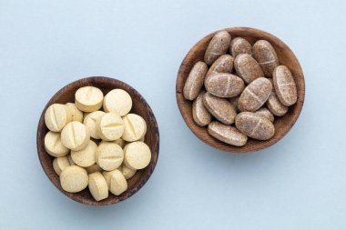 Vitamin hapı tableti, mineral ve takviye maddesi, bitkisel ilaç tozu tıp pastel arka planında fotokopi alanı ile birlikte..