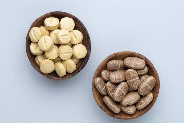 Vitamin hapı tableti, mineral ve takviye maddesi, bitkisel ilaç tozu tıp pastel arka planında fotokopi alanı ile birlikte..