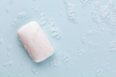 Pastel arka planda sabun çubuğu ve köpük