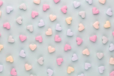 Sevgililer Günü geçmişi. Pastel mavi arka planda şeker kalpli kompozisyon. Sevgililer Günü tebrik kartı. Düz yatış, üst görünüm.