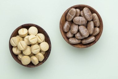 Vitamin hapı tableti, mineral ve takviye maddesi, bitkisel ilaç tozu tıp pastel arka planında fotokopi alanı ile birlikte..