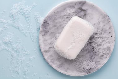 Pastel arka planda sabun çubuğu ve köpük