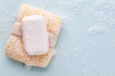 Pastel arka planda sabun çubuğu ve köpük
