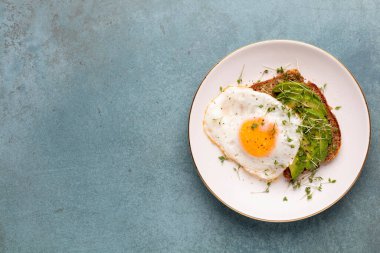 Keto kahvaltısı sahanda yumurta, avokado ve ekmek. Keto diyet kavramı.