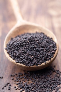 Tahta kaşıkta doğal susam tohumları.