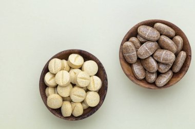 Vitamin hapı tableti, mineral ve takviye maddesi, bitkisel ilaç tozu tıp pastel arka planında fotokopi alanı ile birlikte..