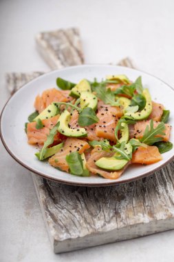 Avokadolu taze somon salatası, keto ve düşük karbonhidrat diyeti için. Paslı arkaplan, üst görünüm, kopyalama alanı.