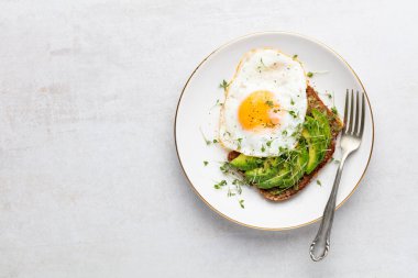 Keto kahvaltısı sahanda yumurta, avokado ve ekmek. Keto diyet kavramı.