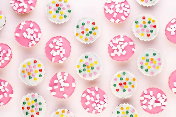 Beyaz arka planda çok renkli, güzel dekore edilmiş muffinler..