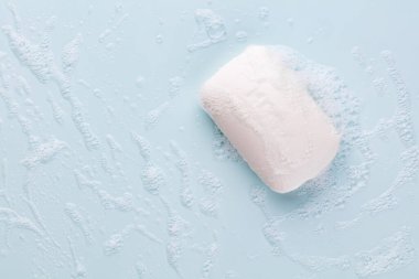 Pastel arka planda sabun çubuğu ve köpük
