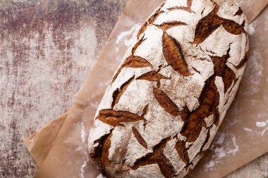 Koyu gri mutfak masasında taze pişmiş ekmek..