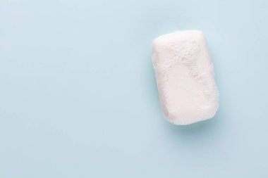Pastel arka planda sabun çubuğu ve köpük