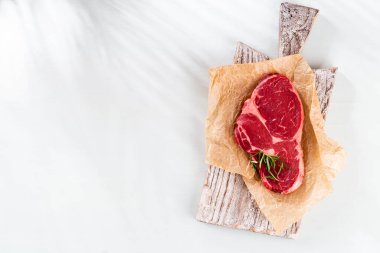 Tahta kesme tahtasının üzerinde taze pirzola, ıspanak, mercimek ve rustik tarzda tespih..