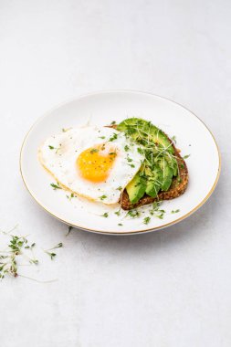 Keto kahvaltısı sahanda yumurta, avokado ve ekmek. Keto diyet kavramı.