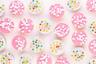 Beyaz arka planda çok renkli, güzel dekore edilmiş muffinler..