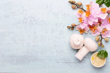 Spa aromaterapi arka planı, basit orkide çiçekleriyle süslenmiş çeşitli güzellik ürünleri..
