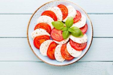 Domates, mozzarella peyniri, fesleğen ve baharatlar gri tahtada. İtalyan geleneksel Caprese salata malzemeleri. Akdeniz yemekleri.