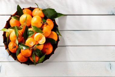 Tahta kutuda yaprakları olan taze mandalina portakalları..