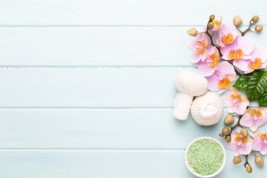 Spa aromaterapi arka planı, basit orkide çiçekleriyle süslenmiş çeşitli güzellik ürünleri..