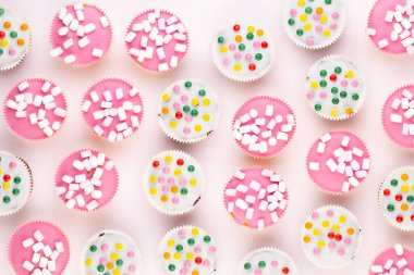 Beyaz arka planda çok renkli, güzel dekore edilmiş muffinler..