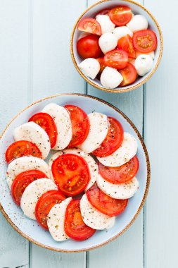 Domates, mozzarella peyniri, fesleğen ve baharatlar gri tahtada. İtalyan geleneksel Caprese salata malzemeleri. Akdeniz yemekleri.