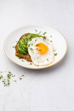 Keto kahvaltısı sahanda yumurta, avokado ve ekmek. Keto diyet kavramı.