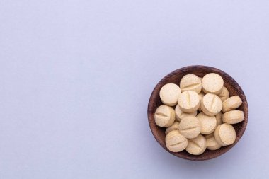 Vitamin hapı tableti, mineral ve takviye maddesi, bitkisel ilaç tozu tıp pastel arka planında fotokopi alanı ile birlikte..