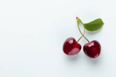 Pasta arkaplan manzaralı kiraz çilekleri. Bir filizin üzerinde kiraz ile arka plan, düz yatıyordu