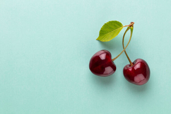 Cherry berries on a pastel background top view.  Background with a cherry on a sprig, flat lay