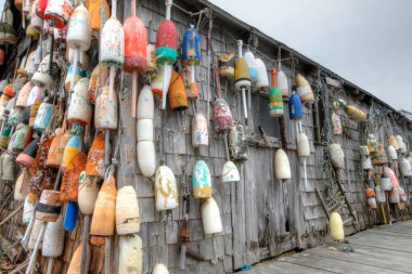 Okyanus kıyısındaki kulübede çeşitli renklerde ıstakoz şamandıraları.