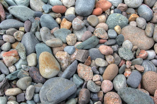 Beach rounded rocks in various colors from erosion