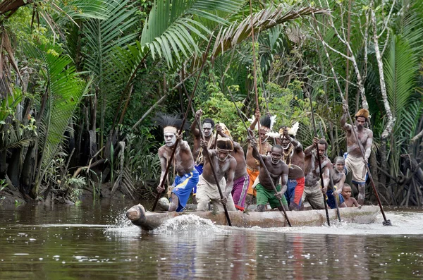 Hombres asmat remando en su canoa dugout — Foto de Stock
