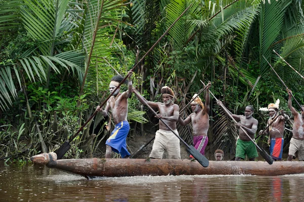 Asmat hommes pagayant dans leur pirogue — Photo