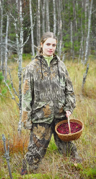 Junge Frau pflückt Preiselbeere auf einem Moor. — Stockfoto