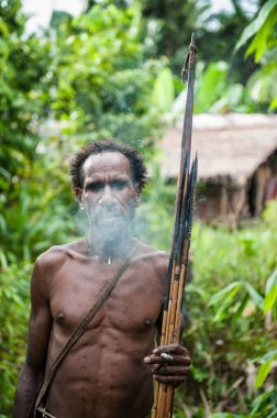 NDONESIA, NEW GUINEA, IRIAN JAYA, ONNI VILLAGE - 27 Haziran 2012: Korowai kabilesinden Papuan. Korowai kombai (Kolufo) doğal orman arka planında yay ve oklarla
