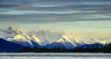Chilkat nehir ve bir gündoğumu karda dağlarda. Alaska.Usa kışın
