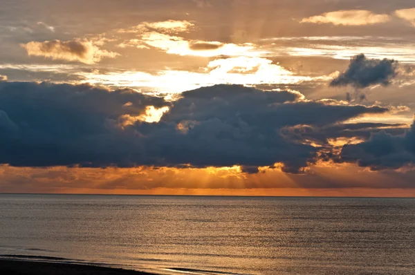 Puesta de sol detrás de nubes masivas — Foto de Stock