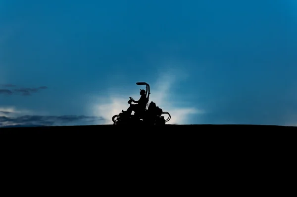 Silhouette eines Rasenmähers am Morgen — Stockfoto