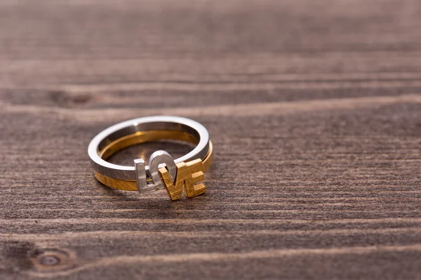 Bague de fiançailles sur table en bois — Photo