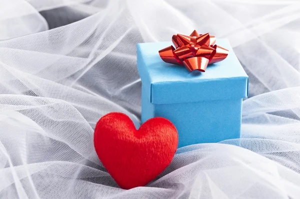 Caja de regalo azul con lazo rojo en el velo de boda — Foto de Stock